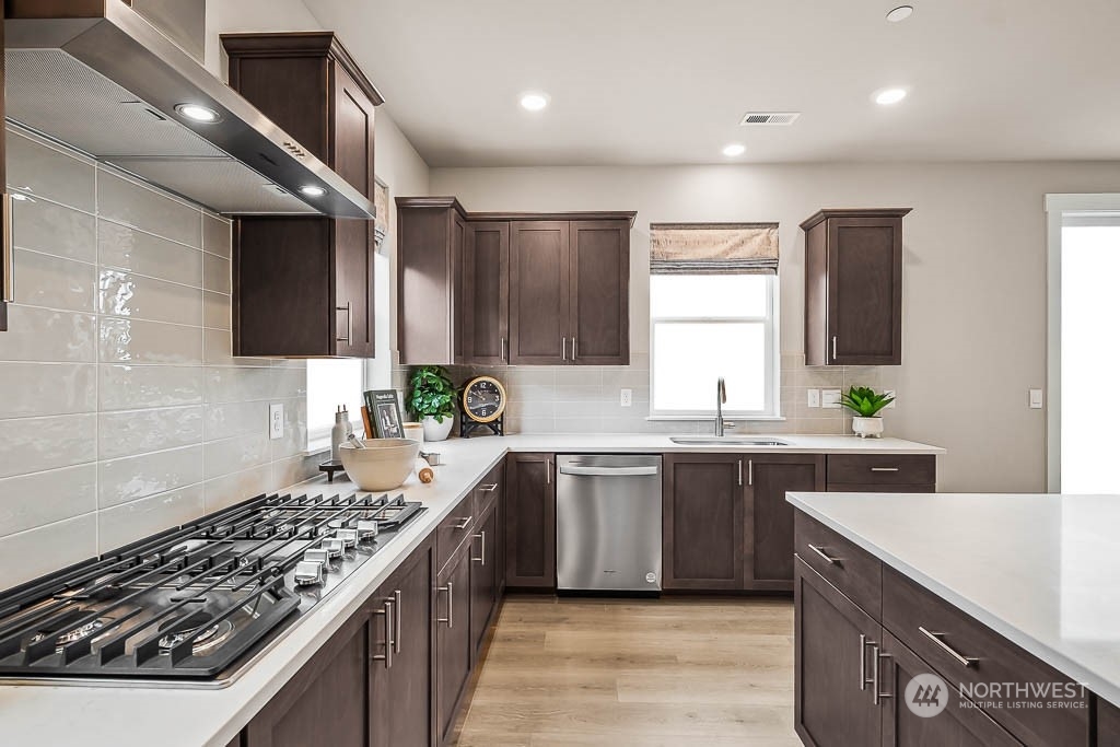 16213 Southeast 133rd Place, Unit 113 Renton, WA 98059 - Photo 15 of 30 a kitchen with stainless steel appliances granite countertop a sink stove and cabinets