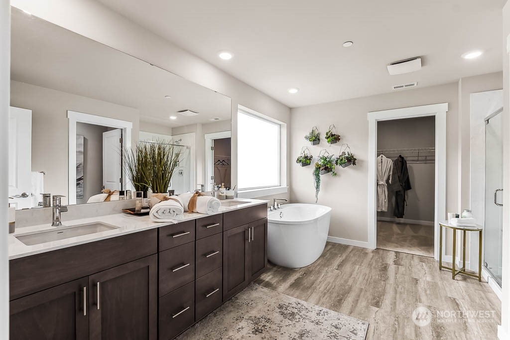16213 Southeast 133rd Place, Unit 113 Renton, WA 98059 - Photo 26 of 30 a spacious bathroom with a double vanity sink a large mirror and a bathtub