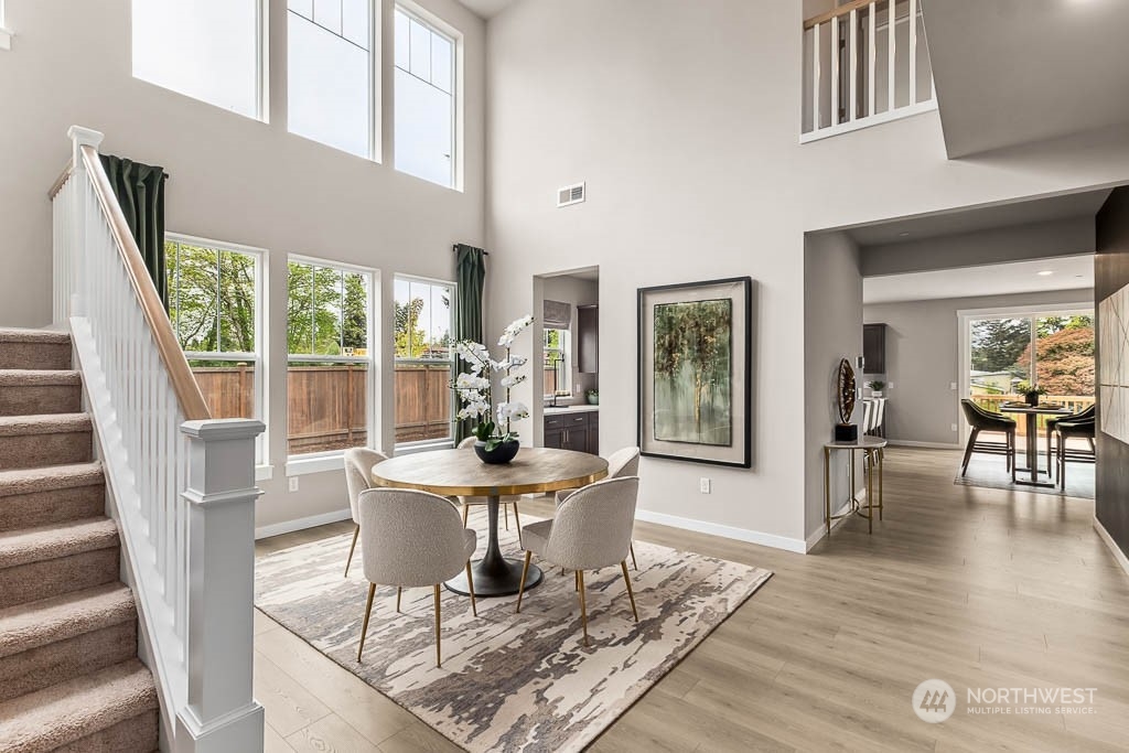 16213 Southeast 133rd Place, Unit 113 Renton, WA 98059 - Photo 6 of 30 a dining room with furniture wooden floor and a rug