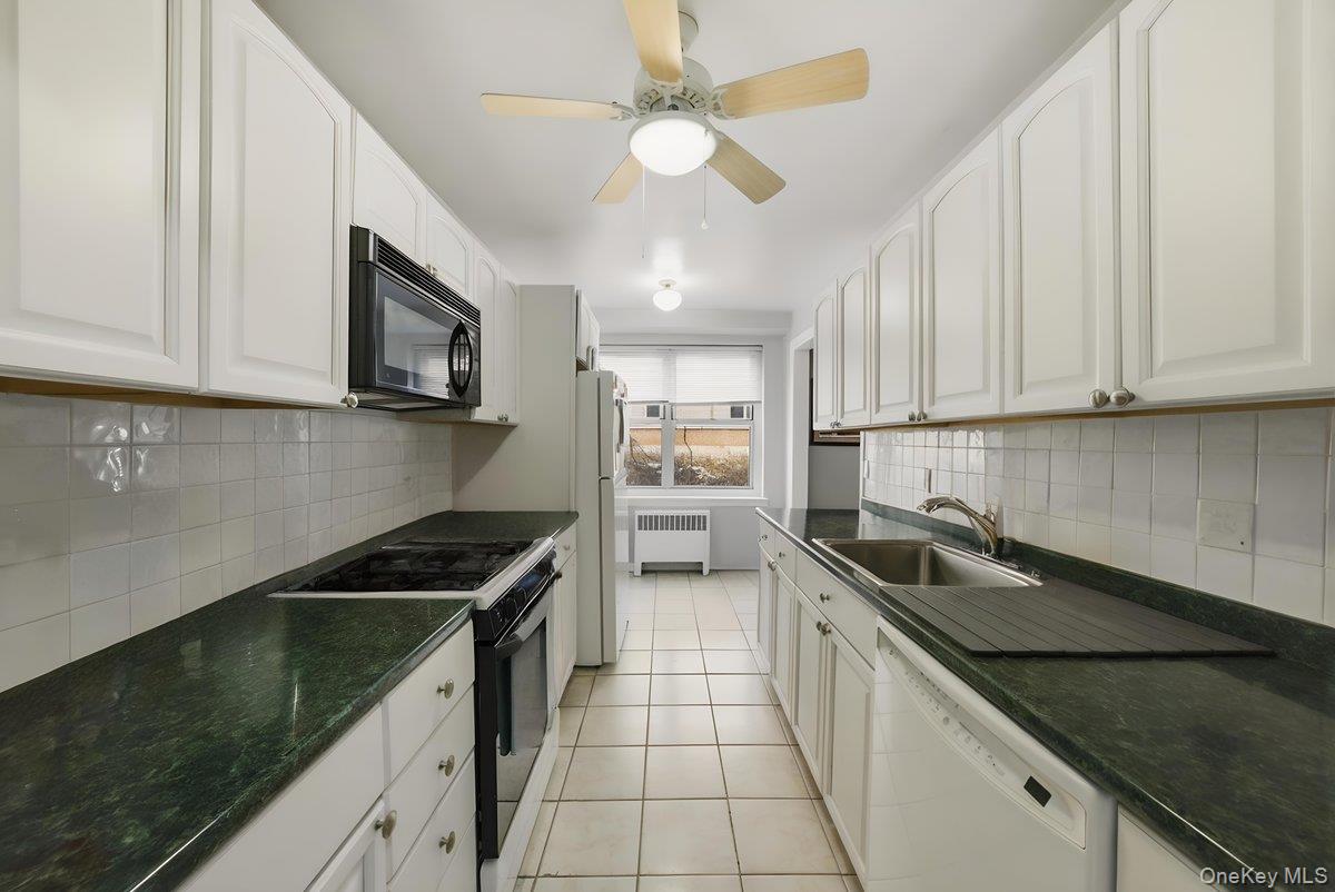781 Palmer Road, Unit 2D Yonkers, NY 10708 - Photo 6 of 17 a kitchen with a sink a stove and cabinets