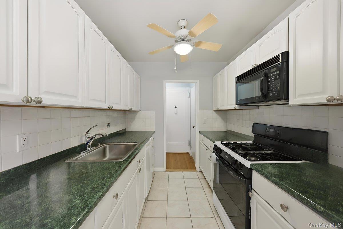 781 Palmer Road, Unit 2D Yonkers, NY 10708 - Photo 7 of 17 a kitchen with stainless steel appliances granite countertop a sink a stove oven a counter space and cabinets
