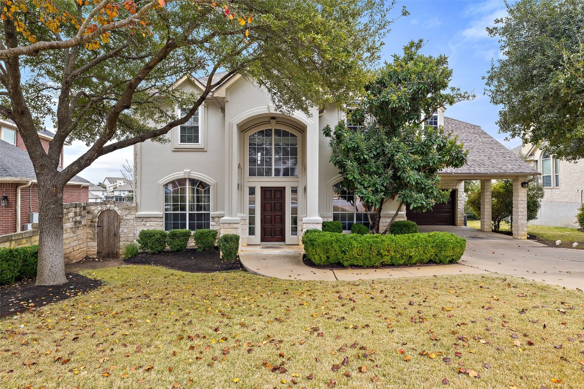 View of front of property with concrete driveway, stone siding, a shingled roof, stucco siding, and a garage