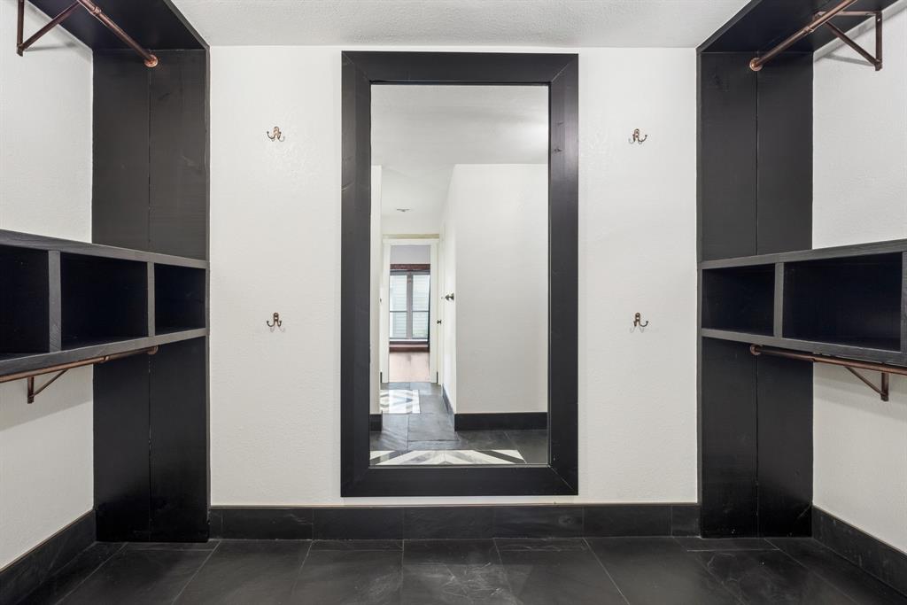 15539 Preston Road, Unit 1037 Dallas, TX 75248 - Photo 27 of 36 Integrated shelving units with copper-toned hanging rods, built-in mirror, and dark tile flooring