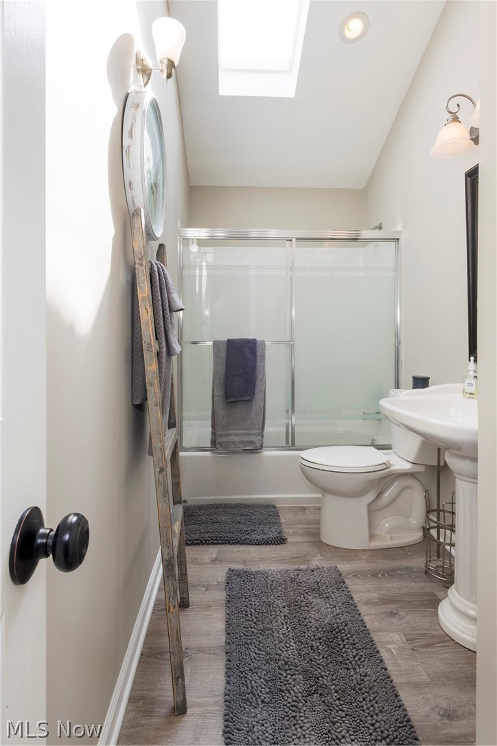 13175 McCracken Road Cleveland, OH 44125 - Photo 25 of 48 Bathroom featuring a skylight, toilet, and enclosed tub / shower combo