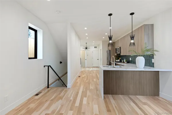 a view of a kitchen with kitchen island white wooden cabinets and wooden floor