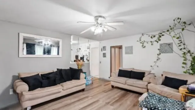 a living room with furniture and a ceiling fan