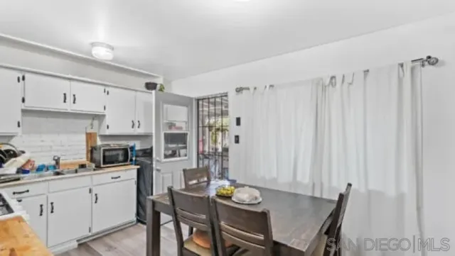 a kitchen with stainless steel appliances a white table and chairs in it