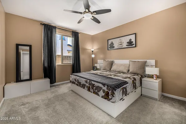 a spacious bedroom with a bed and a chandelier