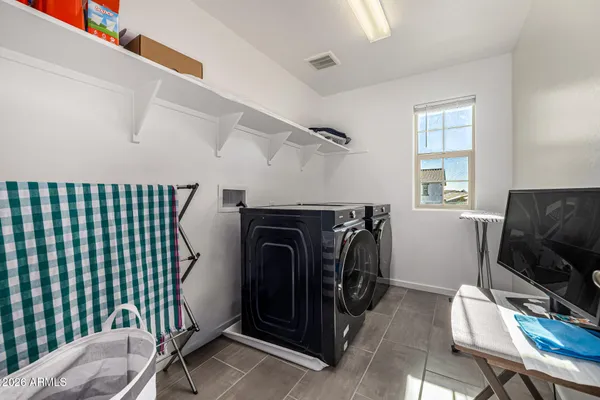 a utility room with dryer and furniture