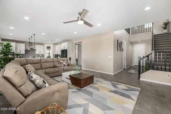 a living room with furniture and a ceiling fan