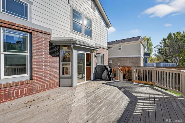 a view of a house with a barbeque and wooden floor