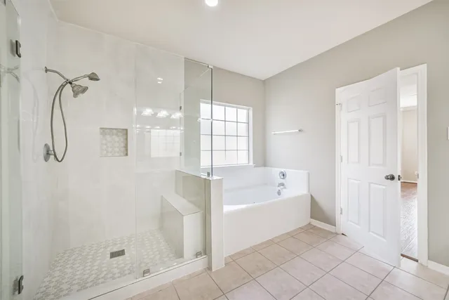 a bathroom with a tub shower and window