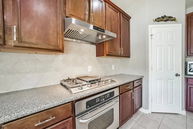 a kitchen with granite countertop white cabinets and stainless steel appliances