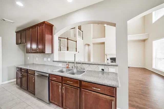 a bathroom with a granite countertop sink a vanity and dishwasher
