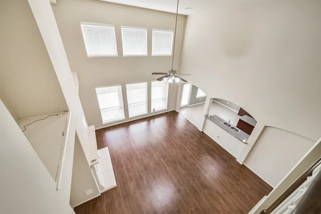 a view of a hallway with wooden floor and stairs