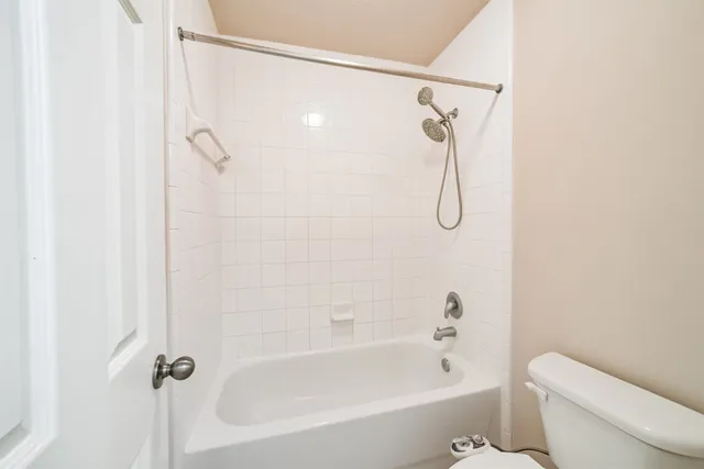 a bathroom with a bath tub with toilet