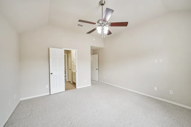 an empty room with a chandelier fan and closet