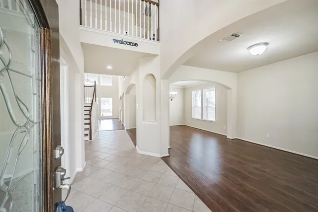 a view of a hallway with wooden floor and windows