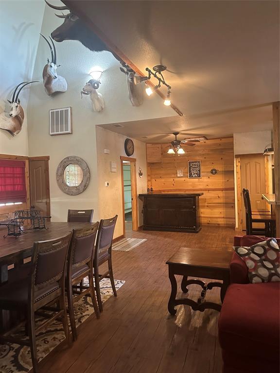 572 Oak Point Drive May, TX 76857 - Photo 11 of 36 Living area featuring hardwood / wood-style floors, wood walls, and ceiling fan