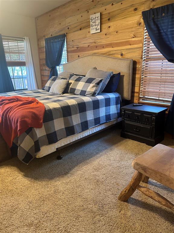 572 Oak Point Drive May, TX 76857 - Photo 22 of 36 Carpeted bedroom featuring wooden walls