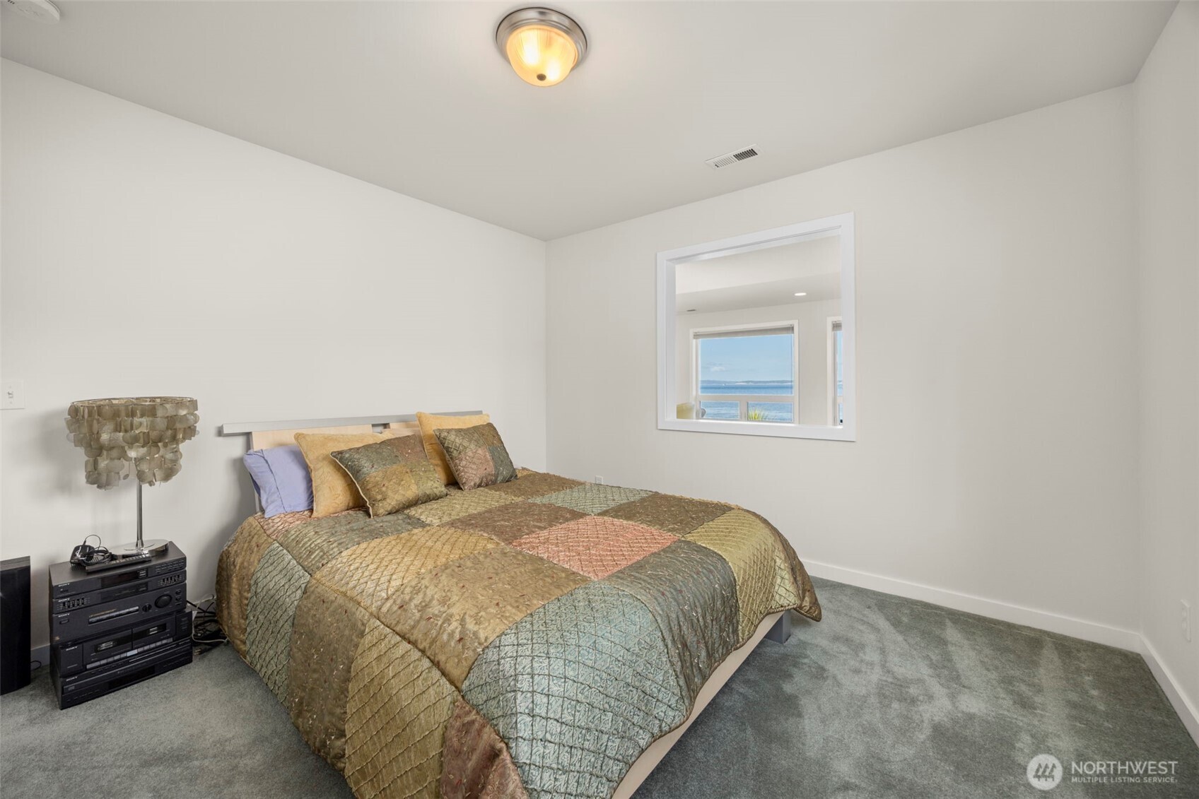 6436 South Ebb Tide Lane Freeland, WA 98249 - Photo 29 of 40 a bed sitting in a bedroom next to a lamp