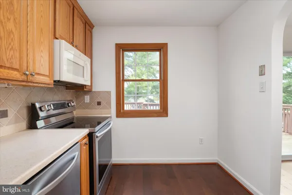 a view of a kitchen with fridge and wooden floor
