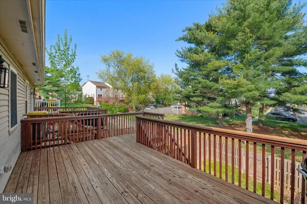 a view of deck with wooden floor and fence next to a yard