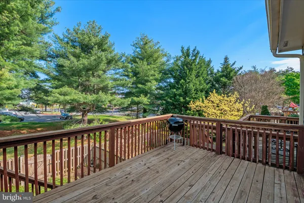 a view of deck with wooden floor and fence next to a yard