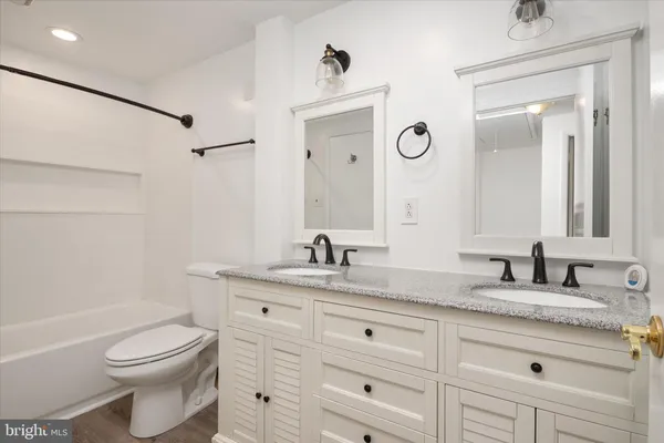 a bathroom with a granite countertop toilet sink and mirror