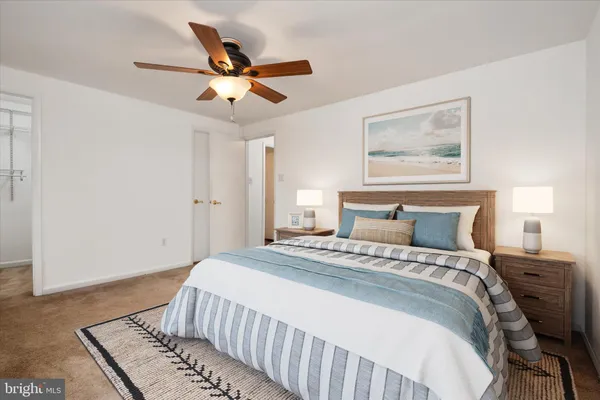 a bedroom with a large bed and a ceiling fan