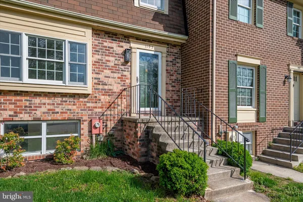 a view of a house with brick walls and a yard with plants