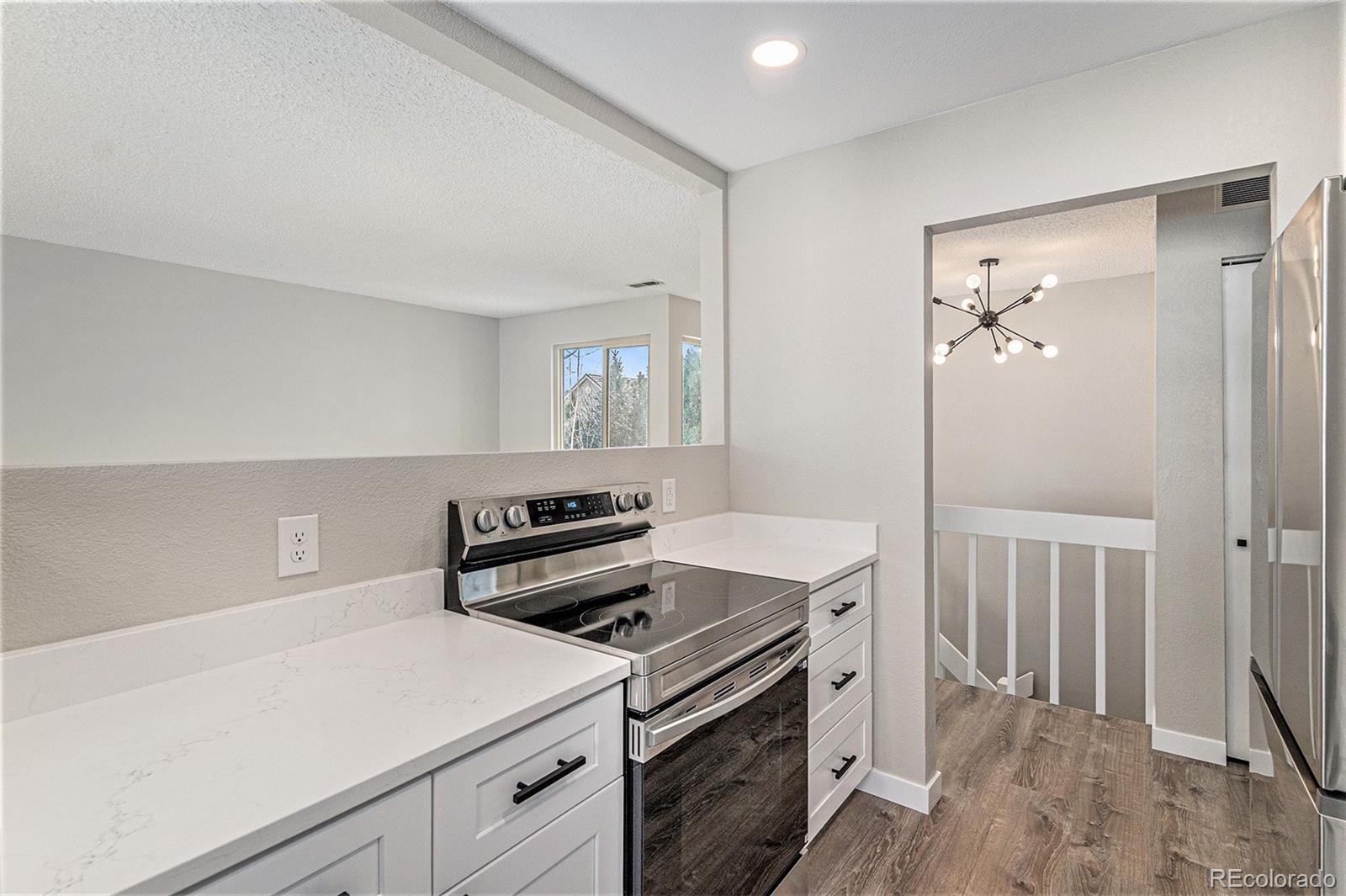 8414 South Everett Way, Unit F Littleton, CO 80128 - Photo 2 of 13 a kitchen with a stove and a refrigerator