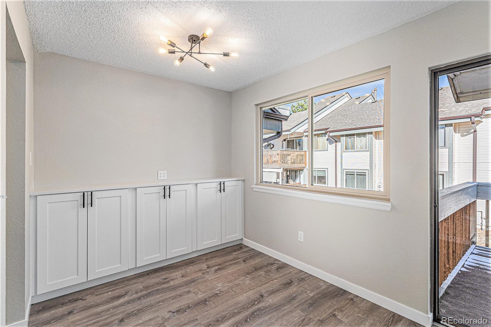 8414 South Everett Way, Unit F Littleton, CO 80128 - Photo 4 of 13 a view of an empty room with a window and wooden floor
