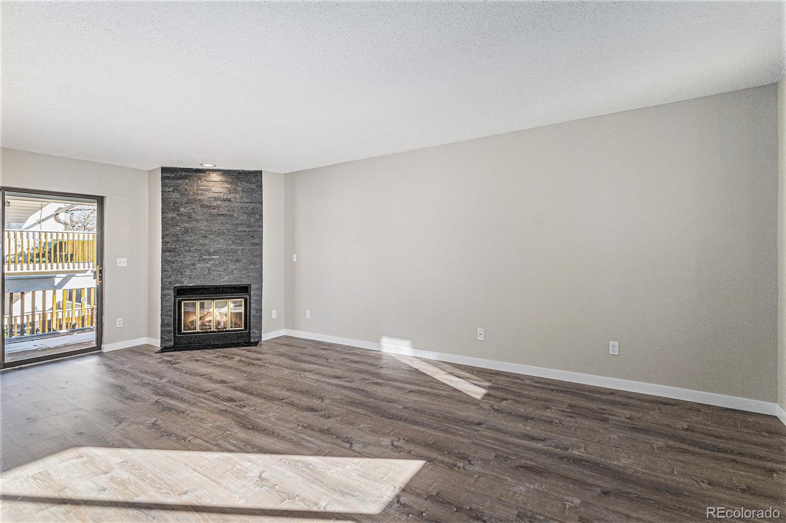 8414 South Everett Way, Unit F Littleton, CO 80128 - Photo 5 of 13 a view of an empty room with a window and fireplace