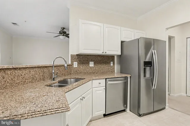 a kitchen with stainless steel appliances granite countertop a refrigerator and a sink