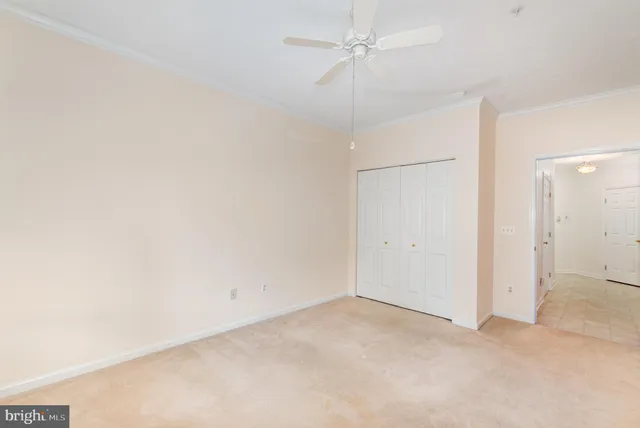 an empty room with a ceiling fan and a window