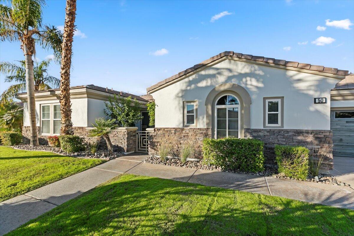 50 Toscana Way East Rancho Mirage, CA 92270 - Photo 69 of 87 a front view of a house with a yard