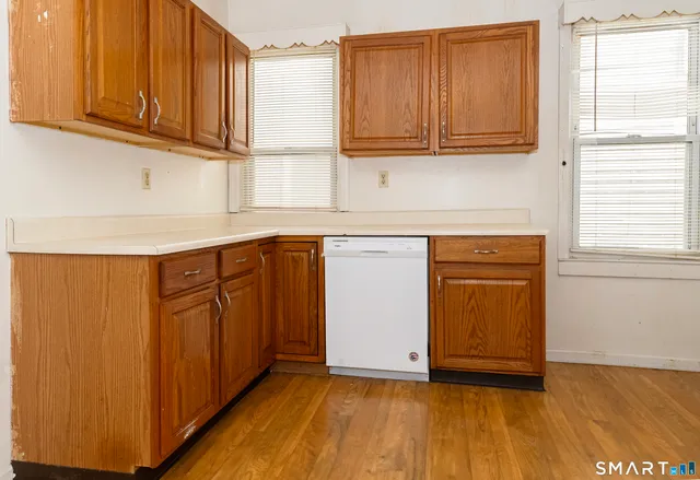 a kitchen with stainless steel appliances granite countertop wooden cabinets a sink and a window