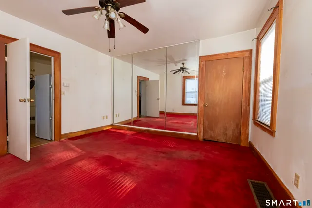 a view of empty room with window and ceiling fan