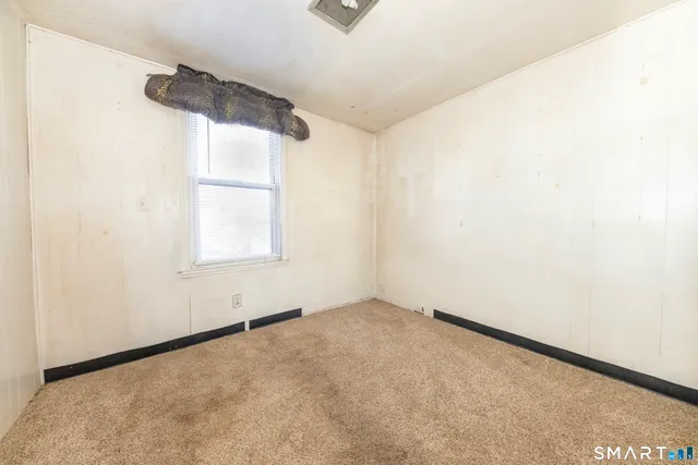 an empty room with windows and closet