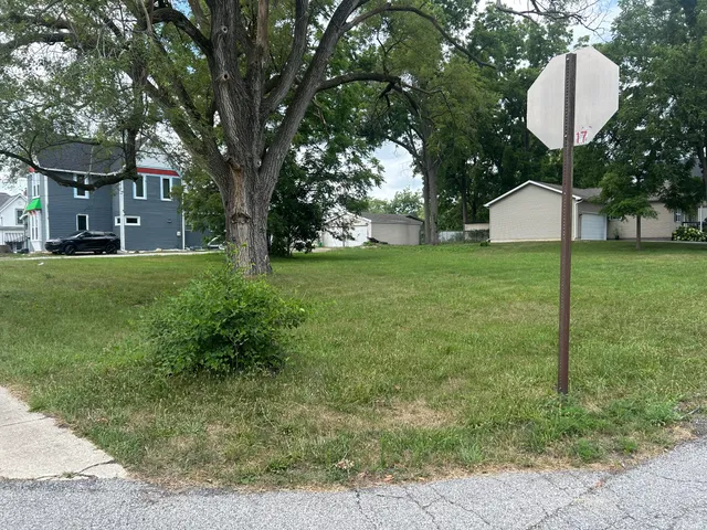 a front view of a house with a garden and trees