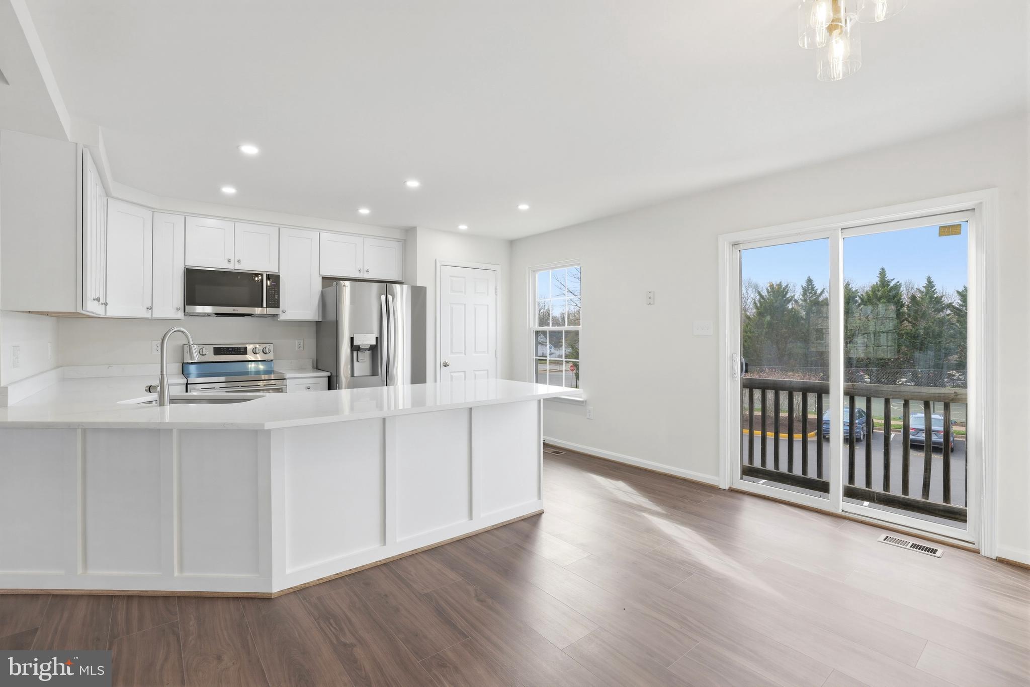 14275 Newbern Loop Gainesville, VA 20155 - Photo 2 of 35 a kitchen with stainless steel appliances granite countertop a stove a sink a refrigerator white cabinets and wooden floor