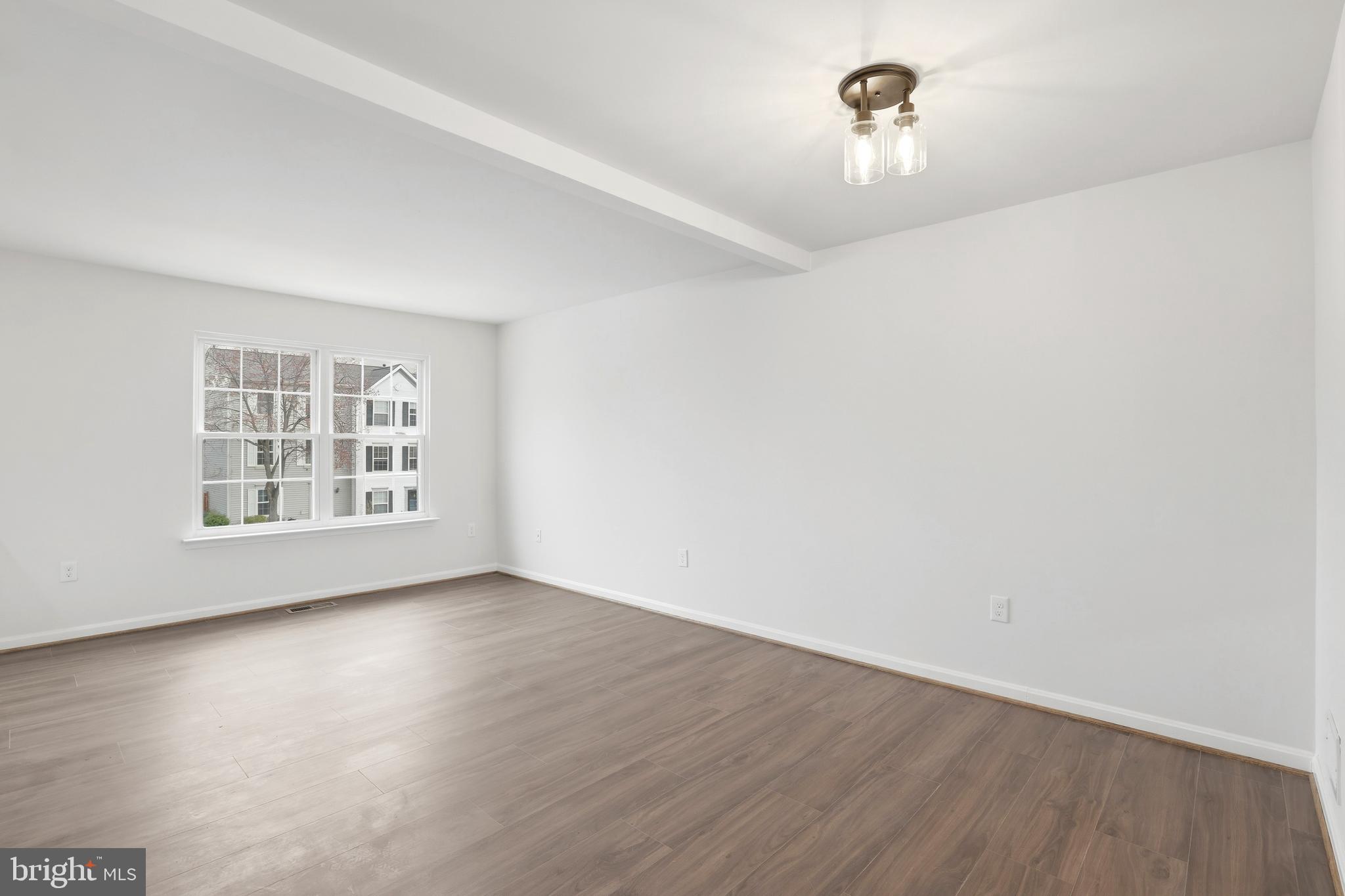 14275 Newbern Loop Gainesville, VA 20155 - Photo 10 of 35 a view of an empty room with wooden floor and a window