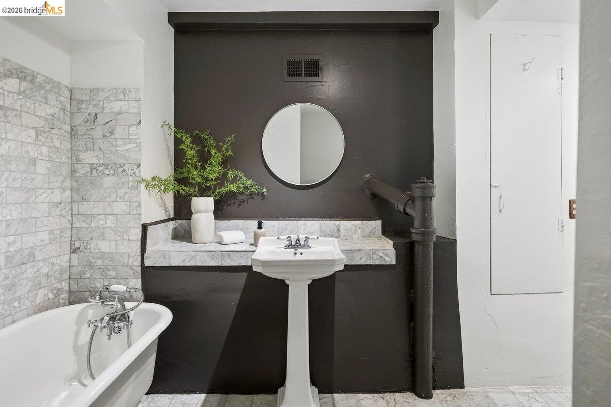 1049 Keith Avenue Berkeley, CA 94708 - Photo 30 of 79 a bathroom with a granite countertop sink and a mirror