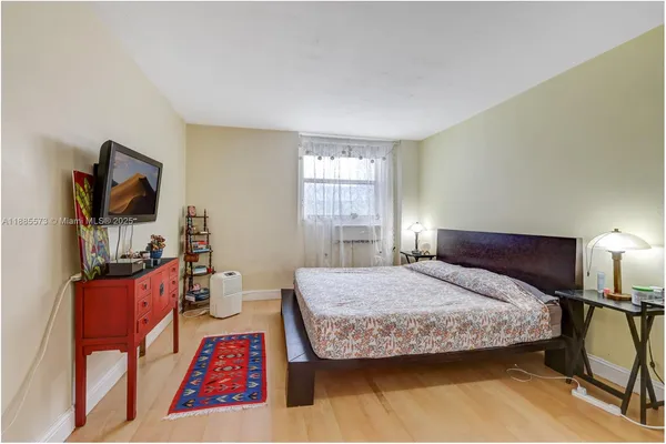 a bedroom with a bed a table and painting on the wall