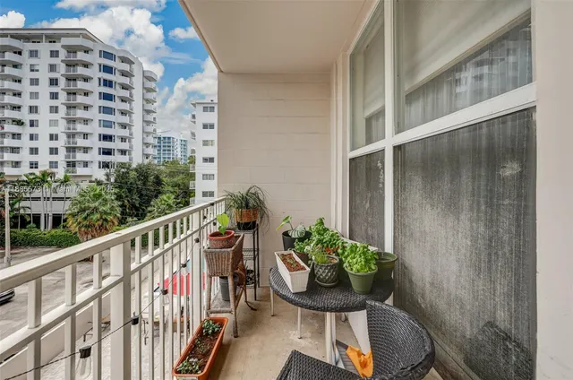 a view of a building with a dining table and chairs under an umbrella