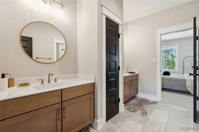 a en suite bathroom with a double vanity sink and a mirror