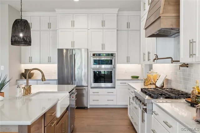 a kitchen with stainless steel appliances granite countertop a stove a sink and a refrigerator