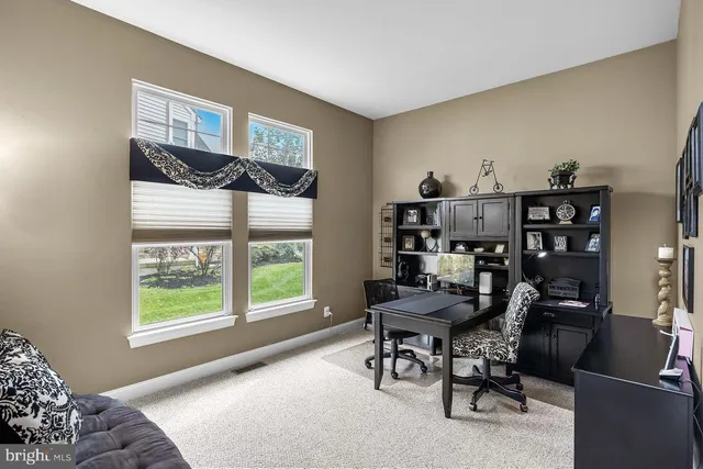 a view of a workspace with furniture and a window