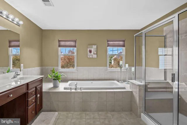 a spacious bathroom with a tub sink and mirror